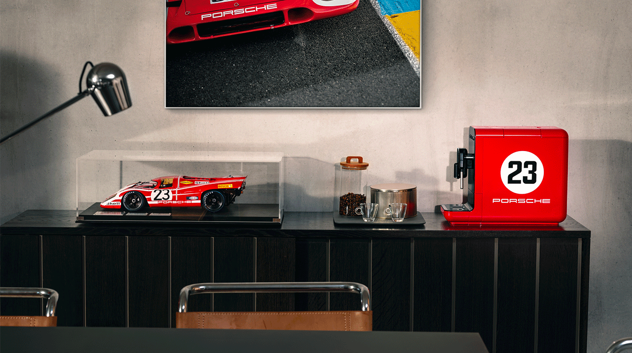 SMEG x Porsche BCC02 espressomachine in interieur met Porsche 917 schaalmodel